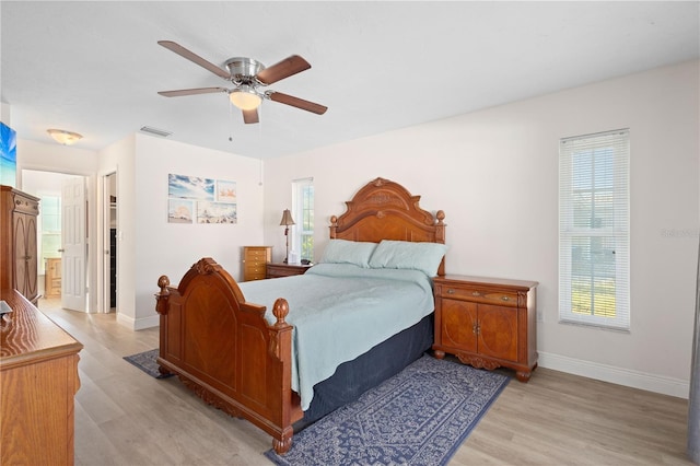 bedroom featuring connected bathroom, light hardwood / wood-style floors, and ceiling fan