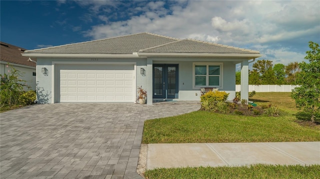 view of front of property featuring french doors, a front lawn, and a garage