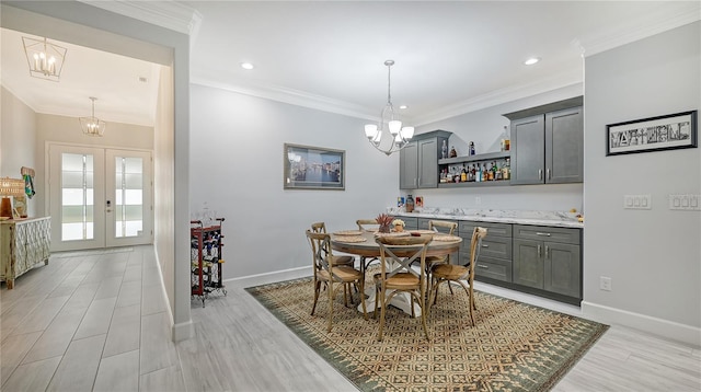 dining space featuring ornamental molding, light hardwood / wood-style flooring, and french doors