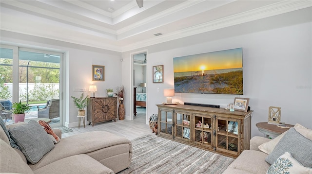 living room with ceiling fan, light wood-type flooring, and crown molding