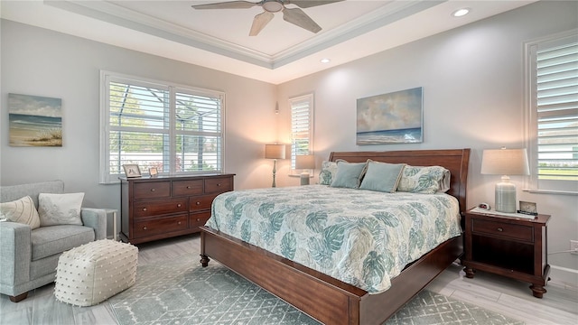 bedroom featuring a raised ceiling, ceiling fan, crown molding, and light hardwood / wood-style floors