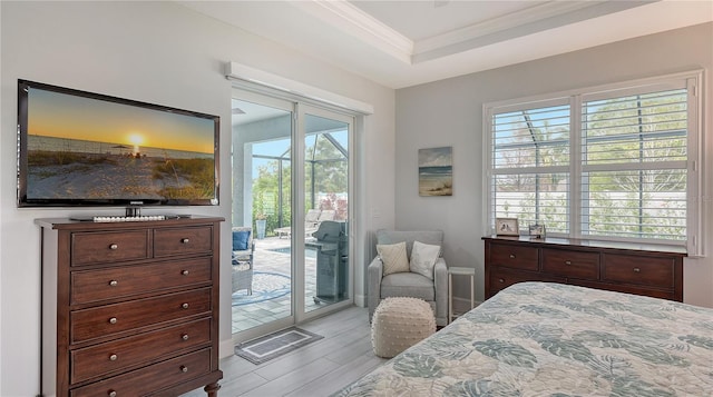 bedroom with a raised ceiling, crown molding, access to outside, and multiple windows