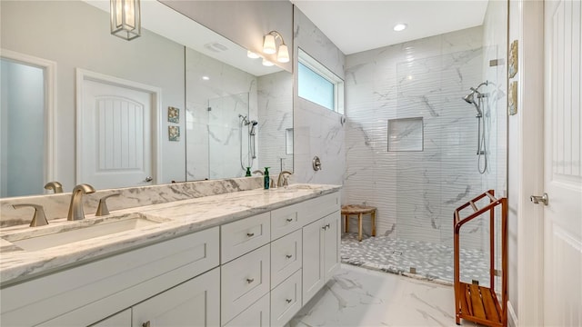 bathroom featuring a tile shower and vanity