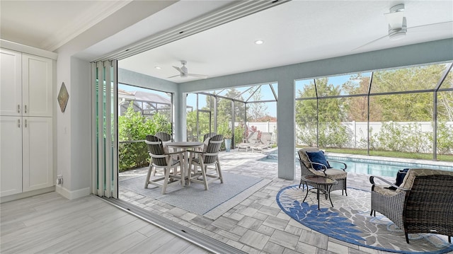 sunroom featuring a pool, ceiling fan, and a healthy amount of sunlight