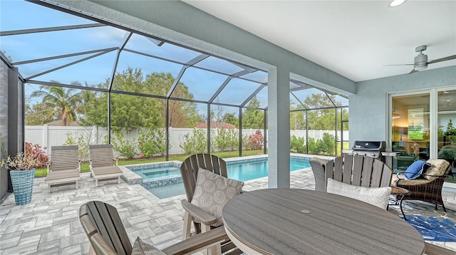 view of patio with a swimming pool with hot tub, area for grilling, glass enclosure, and ceiling fan