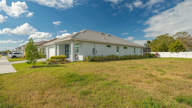 view of side of property featuring a lawn and a garage