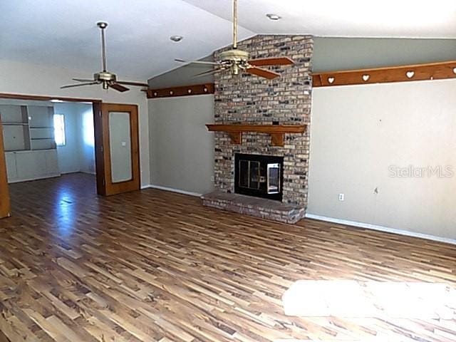 unfurnished living room with a fireplace, hardwood / wood-style floors, vaulted ceiling, and ceiling fan