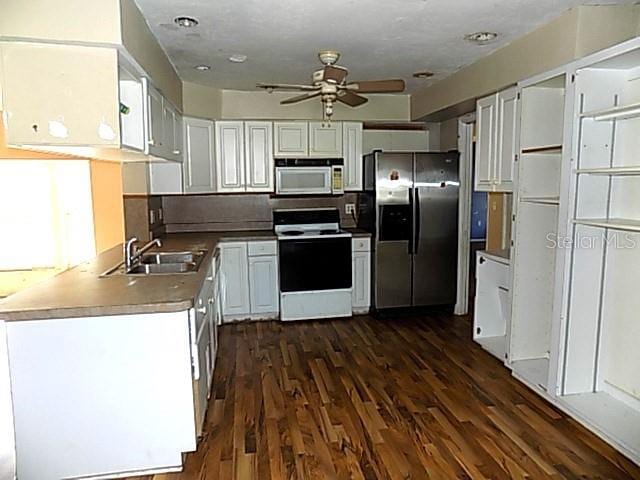 kitchen with ceiling fan, sink, dark hardwood / wood-style floors, white appliances, and white cabinets