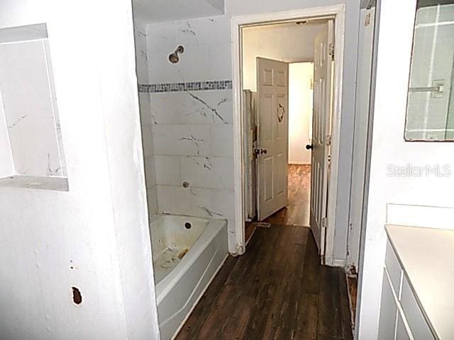 bathroom featuring hardwood / wood-style floors, vanity, and tiled shower / bath