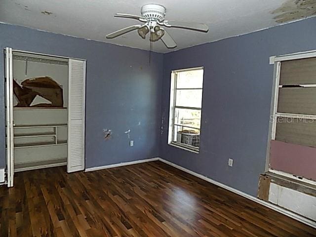 unfurnished bedroom with a closet, ceiling fan, and dark wood-type flooring