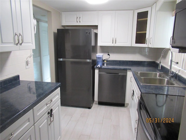 kitchen featuring backsplash, white cabinetry, sink, and stainless steel appliances