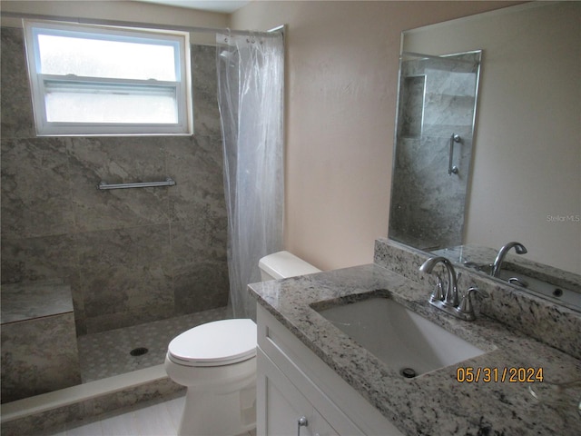 bathroom with vanity, a shower with shower curtain, and toilet