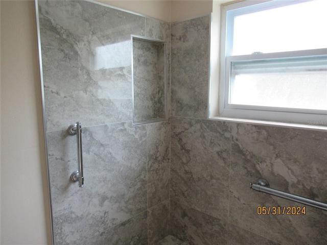 bathroom featuring a healthy amount of sunlight and tiled shower