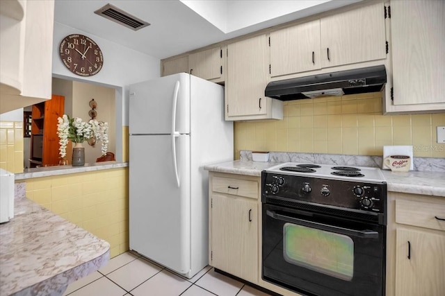 kitchen featuring decorative backsplash, black electric range oven, white fridge, and light tile patterned floors