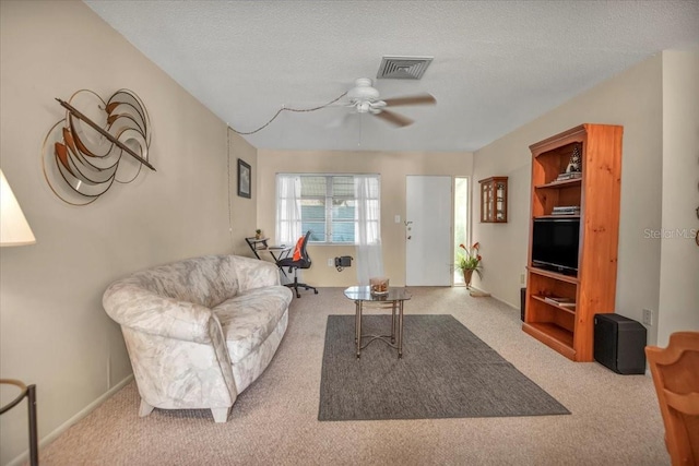 carpeted living room with ceiling fan and a textured ceiling