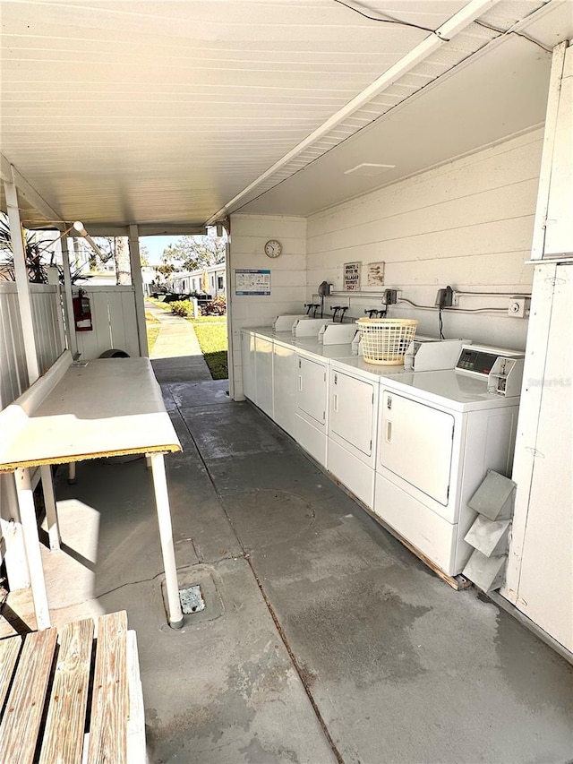 laundry area with wood walls and separate washer and dryer