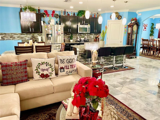 living room with ornamental molding and a notable chandelier