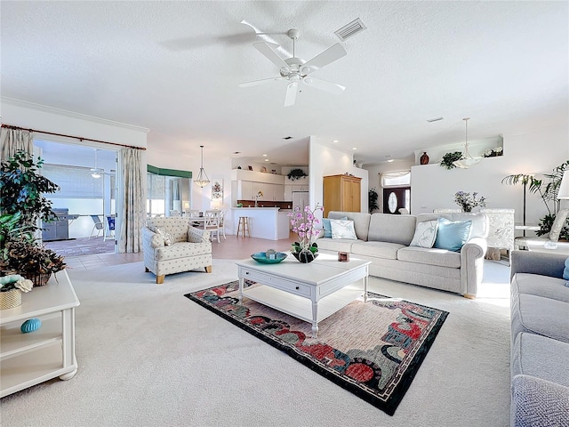 living room featuring sink, ceiling fan, light colored carpet, and a textured ceiling