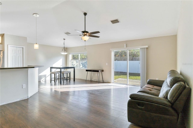 living room with ceiling fan and dark hardwood / wood-style flooring