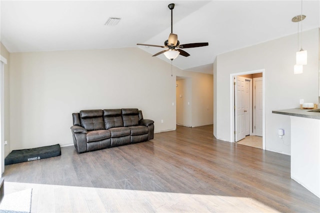 living room featuring ceiling fan, hardwood / wood-style floors, and vaulted ceiling