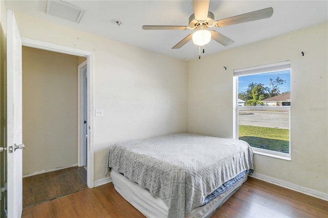 bedroom featuring multiple windows, ceiling fan, and dark hardwood / wood-style flooring