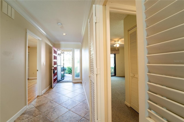 corridor featuring light tile patterned flooring and crown molding