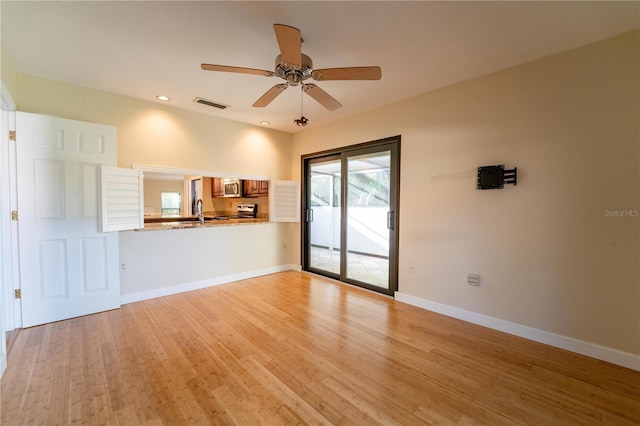 unfurnished living room with light hardwood / wood-style floors, ceiling fan, and sink