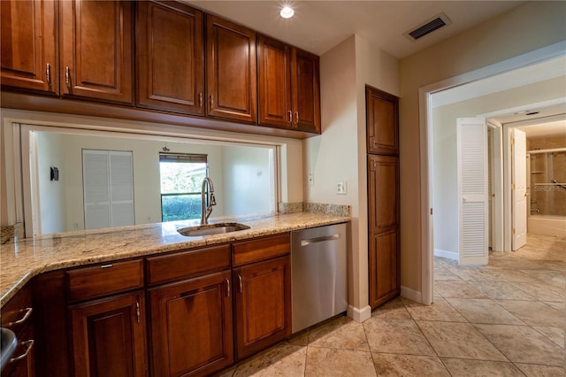 kitchen with dishwasher, light tile patterned floors, light stone countertops, and sink