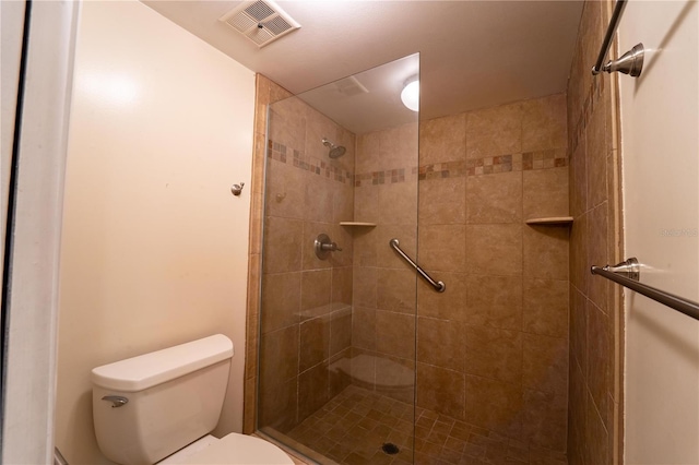 bathroom featuring toilet and a shower with door