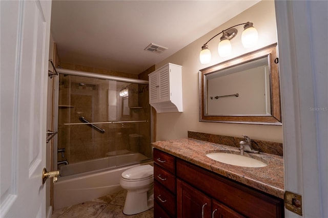 full bathroom featuring toilet, vanity, tile patterned floors, and combined bath / shower with glass door