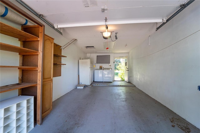 garage with washer and dryer and white fridge