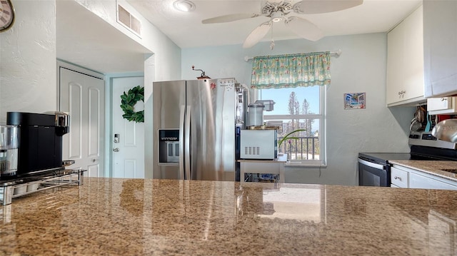 kitchen with light stone countertops, white cabinets, and stainless steel appliances