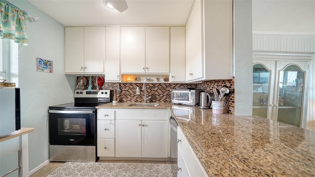 kitchen with light stone counters, white cabinetry, stainless steel electric stove, and sink