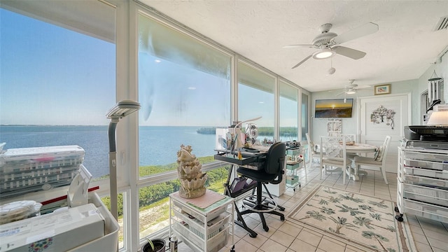 office area with floor to ceiling windows, a textured ceiling, ceiling fan, light tile patterned floors, and a water view