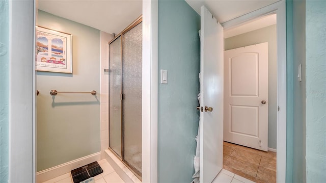 bathroom with tile patterned flooring and a shower with shower door