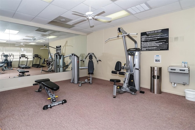 gym featuring ceiling fan, a drop ceiling, and carpet