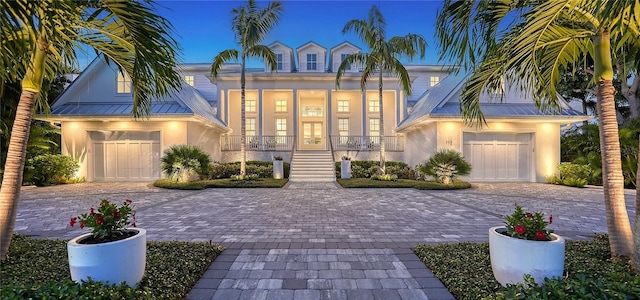 view of front of property featuring covered porch, french doors, and a garage