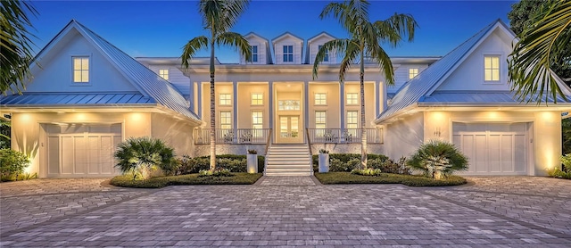 view of front of home with french doors, a porch, and a garage