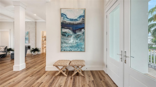 foyer entrance featuring beamed ceiling, french doors, and light hardwood / wood-style flooring