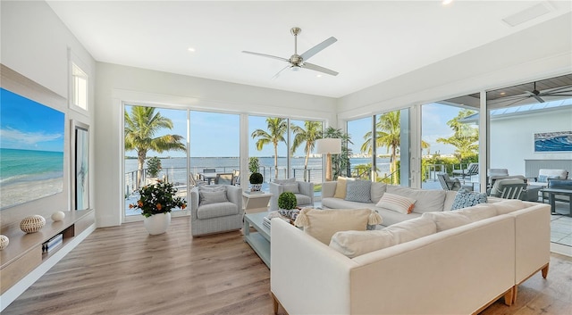 sunroom featuring a water view and ceiling fan