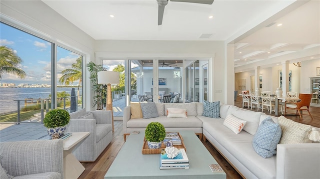 sunroom with a water view and ceiling fan