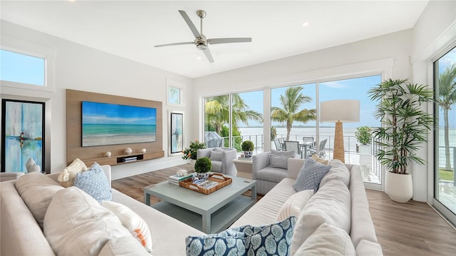 sunroom / solarium featuring a water view and ceiling fan