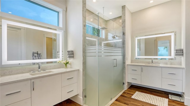 bathroom with vanity, wood-type flooring, a shower with shower door, and backsplash