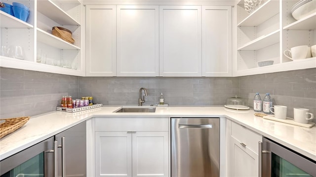 kitchen featuring tasteful backsplash, sink, white cabinets, and beverage cooler