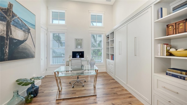 office area with built in features and light wood-type flooring