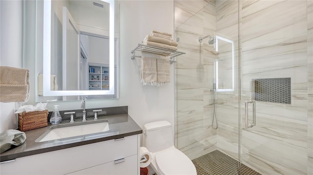 bathroom featuring vanity, toilet, and an enclosed shower