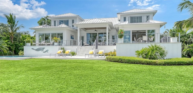 back of property with ceiling fan, a yard, pool water feature, a balcony, and a patio area