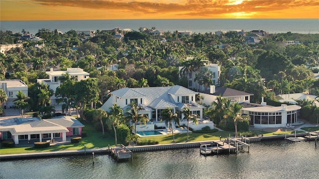 aerial view at dusk featuring a water view