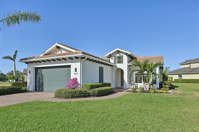 mediterranean / spanish home with a front yard and a garage