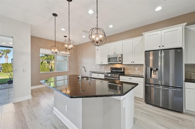 kitchen featuring sink, white cabinetry, a kitchen island with sink, and appliances with stainless steel finishes